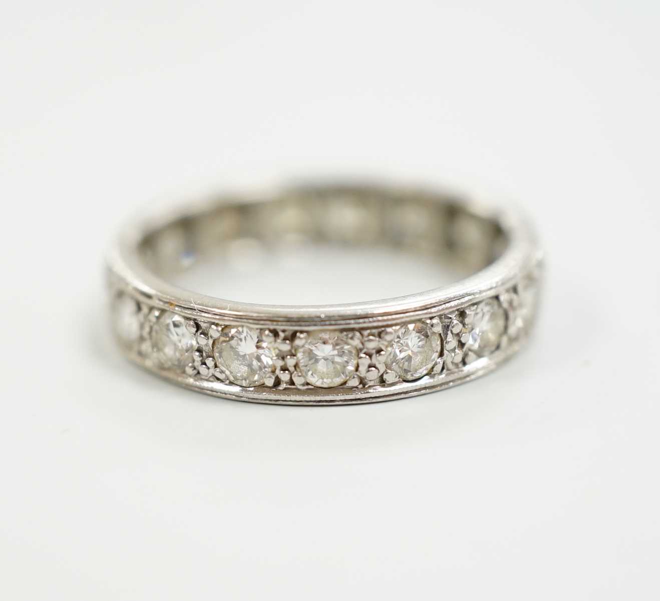 A white metal and diamond set full eternity ring, size M, gross weight 3.9 grams.